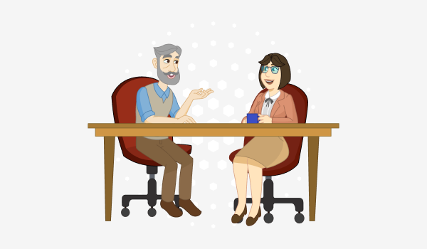 A man and a woman talking at a table in an office setting. 
