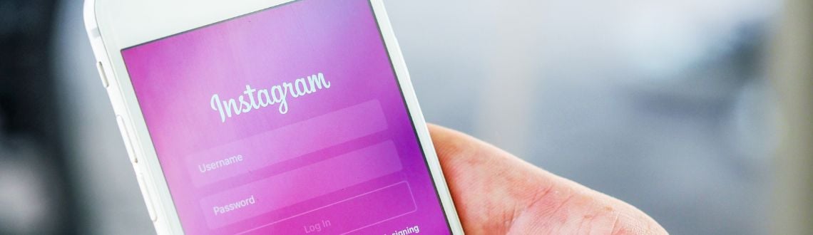 A white phone with a purple screen showing the Instagram login page