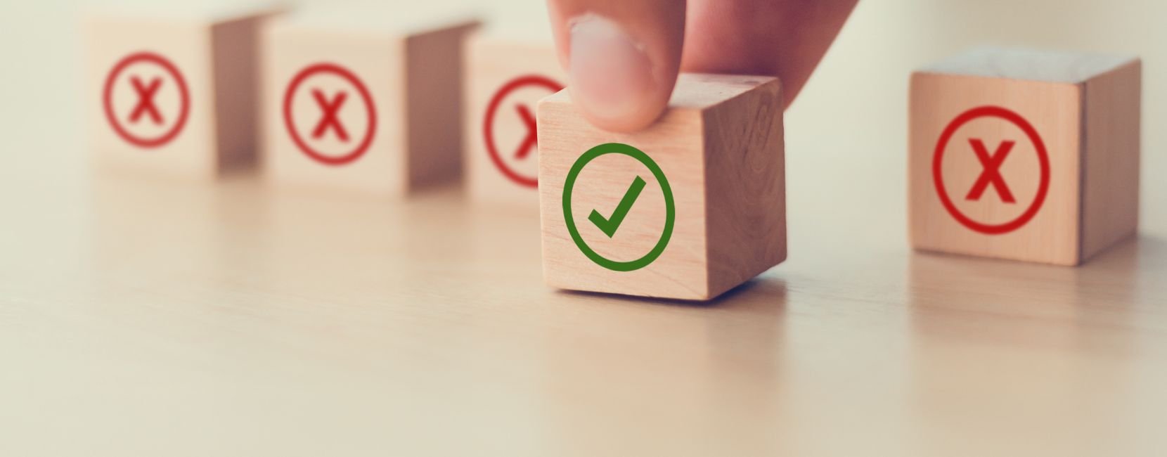 A hand pushing forward a block with a green checkmark on it, with blocks with red Xs in the background.