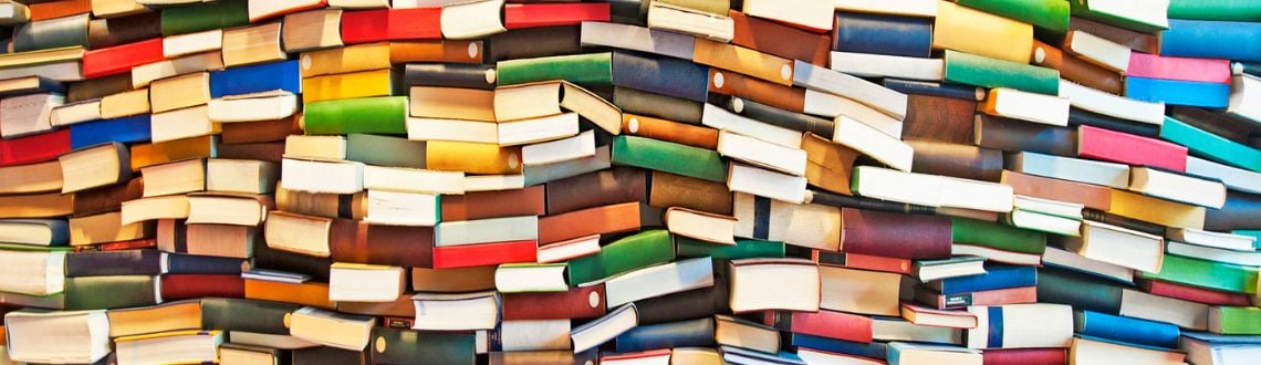 A large stack of colorful books laying on their sides