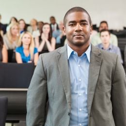 An African-American male professor standing in front of a group of college students