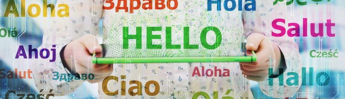 A child's hands holding a green tablet with the word HELLO in different languages superimposed on the photo