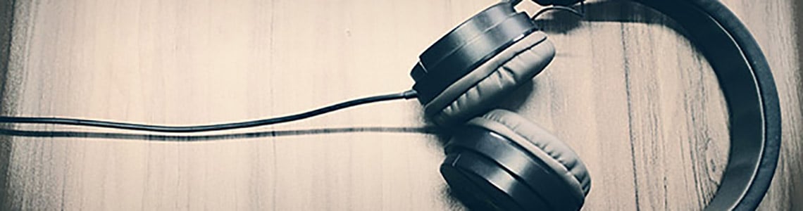 An image of headphones on a wooden table