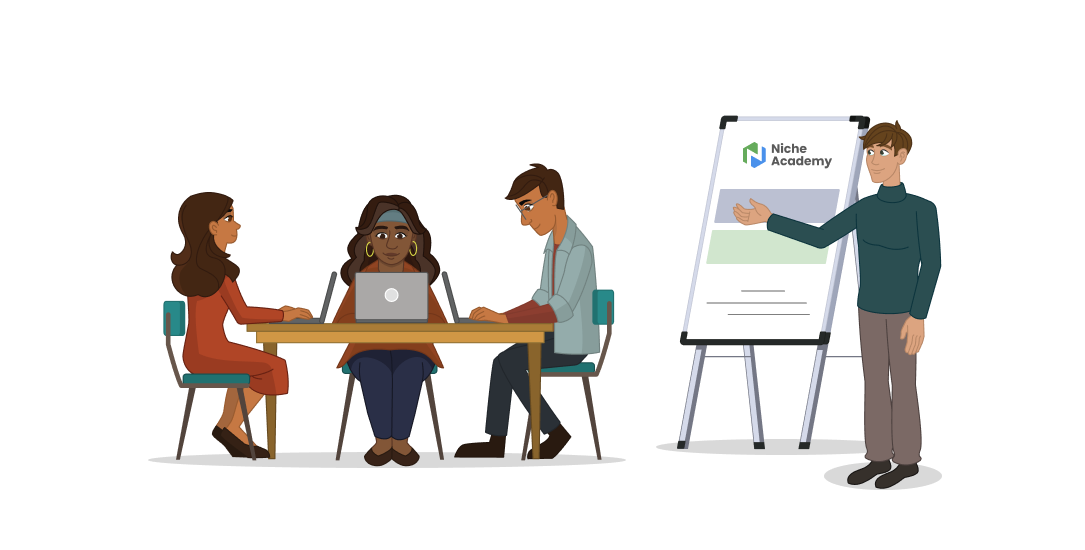 A man stands in front of a whiteboard training a group of people at a table with computers. 