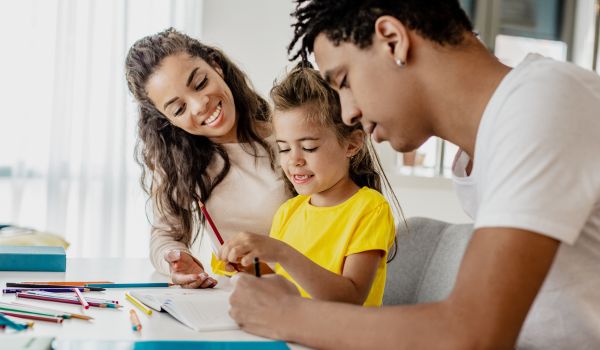 A man and woman helping a girl with a project